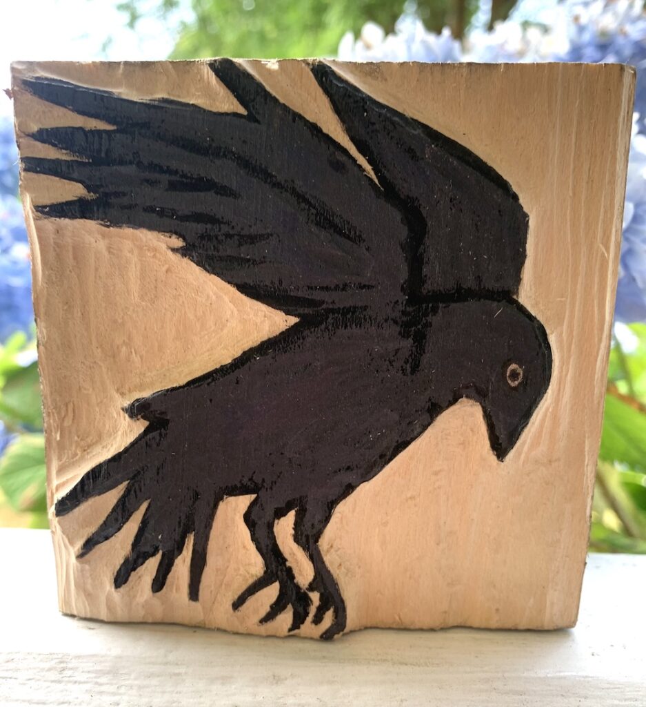 Black crow in flight, carved in wood block